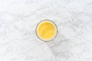 Düz yatıyordu. Islak malzemeleri büyük bir bardakta karıştırıp yumurta likörü pişirmek için karıştırıyorum..