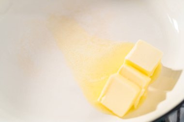 Ispanaklı sarımsaklı karides makarna hazırlamak için dökme demir tavada marine edilmiş karides..