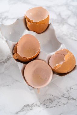 Büyük bir bardakta ıslak malzemeler karıştırarak kırmızı kadife kekler ve beyaz çikolatalı ganache kreması pişiriyorum..