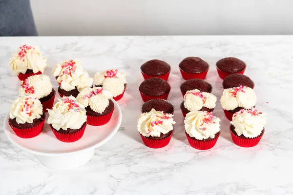 Φρύξη Λευκής Σοκολάτας Πάνω Κόκκινα Βελούδινα Cupcakes Και Συμπλήρωση Τρούφα — Φωτογραφία Αρχείου
