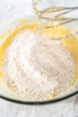 Mini vanilyalı kekler ve ombre pembe kremalı krema pişirmek için büyük bir karıştırma kabında malzemeler karıştırılıyor..