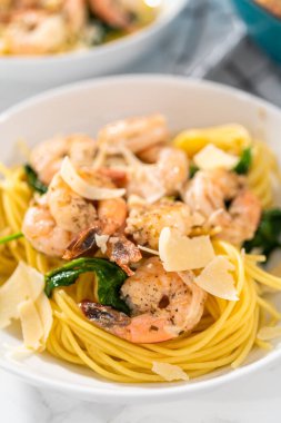 Beyaz seramik kaselerde ıspanaklı sarımsaklı karides makarnası servis ediyorum..