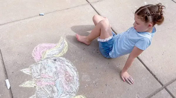 Kleines Mädchen Zeichnet Einem Sommertag Kreidekunst Auf Einer Vorstadteinfahrt — Stockfoto