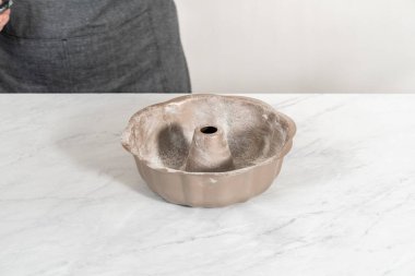 Limonlu kek pişirmek için sebze boyası ve un ile yağlı metal kek tepsisi..