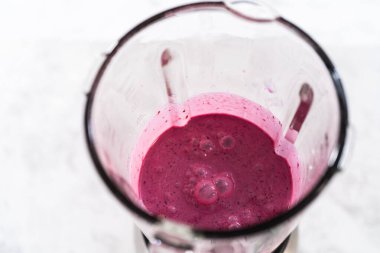 Karışık dut suyu hazırlamak için mutfak blendırında malzemeler karıştırılıyor..