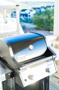 Denver, Colorado, ABD-Haziran 3, 2023-Webers gösterişli, kapalı iki ocaklı ızgara, düşünceli bir şekilde bir banliyö evinin balkonuna yerleştirilmiş, enfes bir açık hava pişirme deneyimi için hazır.