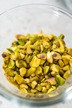 Measured ingredients in glass mixing bowls to make chocolate pistachio fudge.