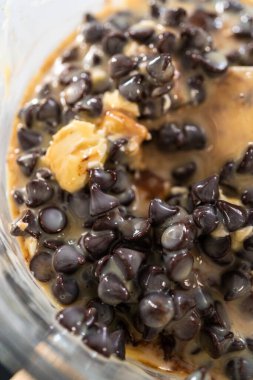 Çikolata parçacıkları ve diğer malzemeleri kaynayan suyun üzerinde karıştırarak çikolatalı şekerleme ve fıstık ezmesi karışımı hazırlıyorum..