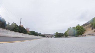 Yağmurlu bir kış gününün ortasında, Los Angeles, Kaliforniya yakınlarındaki HWY 134 'te, yağmur damlalarıyla kaplı lenslerle atmosferi yakalıyor, ve bu yolculuğa benzersiz ve dengesiz bir perspektif ekliyor..