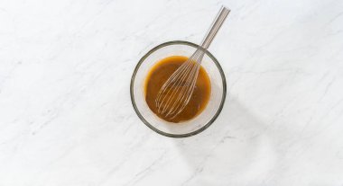 Flat lay. Mixing wet ingredients in a small glass mixing bowl to bake gingerbread bundt cake with caramel filling.