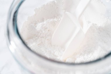 Ev yapımı kraliyet kreması yapmak için büyük bir cam karıştırma kabında malzemeleri karıştırıyorum..