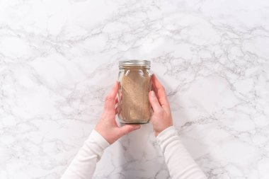 Flat lay. Dry yeast in a glass mason jar on the marble surface