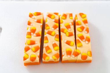 Beyaz bir kesme tahtasının üzerinde şekerli mısır şekerini kare parçalara ayırmak..