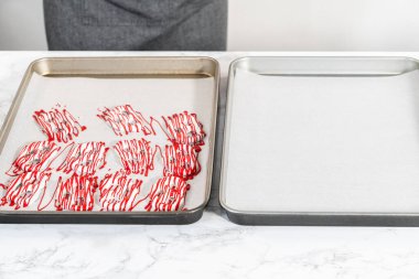 Çikolata soslu krakerlerin üzerine erimiş çikolata serpiştirmek..