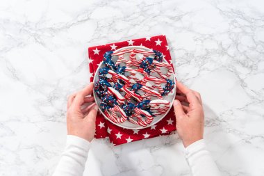 Flat lay. American flag. Red, white, and blue chocolate-covered pretzel twists.