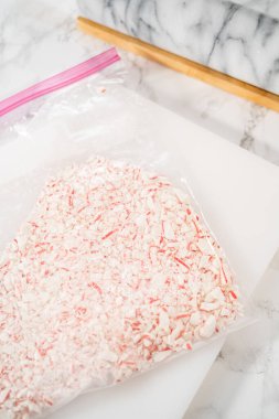 Nane şekerlerini beyaz bir kesim tahtasının üzerinde mermer bir raptiyeyle plastik bir çantada ezmek..