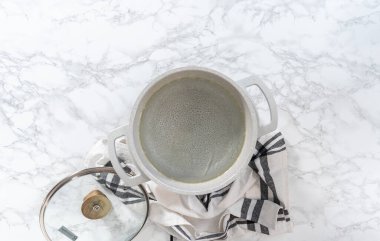 Düz yatıyordu. Makarna ve peynirli brokoli hazırlamak için tencerede kaynar su var..