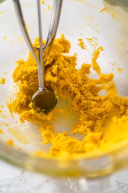 Beyaz çikolatalı limonlu kurabiye. Beyaz çikolatalı limonlu kurabiye pişirmek için parşömen kağıdıyla kaplı bir yemek tepsisine hamur kepçesiyle kurabiye pişirmek..