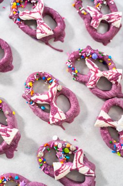 Decorating chocolate-dipped pretzels twists with chocolate mermaid tails.