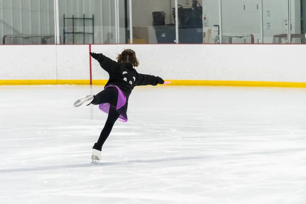 若いです女の子完成彼女のフィギュアスケートルーチン中に彼女の競争服で彼女の屋内アイスリンク — ストック写真