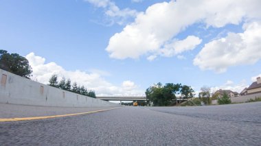 Açık bir kış gününde, bir araba, Santa Maria, California yakınlarındaki 101. Otoyol boyunca yeşil ve altın renkli bir karışımla çevrili, parlak mavi bir gökyüzünün altında sorunsuzca seyahat eder..