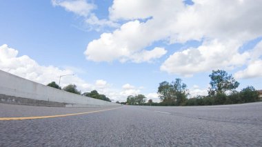 Açık bir kış gününde, bir araba, Santa Maria, California yakınlarındaki 101. Otoyol boyunca yeşil ve altın renkli bir karışımla çevrili, parlak mavi bir gökyüzünün altında sorunsuzca seyahat eder..