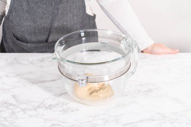 Büyük bir bardaktaki malzemeleri karıştırıyorum. Pizza hamuruyla karıştırıyorum..