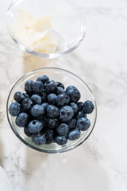 Cam kasenin içindeki malzemeleri birleştirmek, lezzetli bir vanilyalı kek hazırlamak için ustalıkla çırpmak..