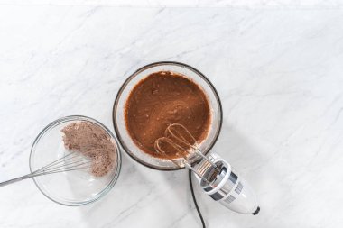 Düz yatıyordu. Kırmızı kadife kek ve krem peynir jöleli kek yapmak için büyük bir bardakta karıştırma malzemesi..