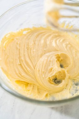 Krem peyniri kek yapmak için büyük bir bardakta karıştırma malzemesi..