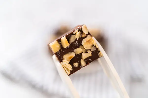 Holding Homemade Chocolate Hazelnut Fudge Square Piece Kitchen Tongs — Stock Photo, Image