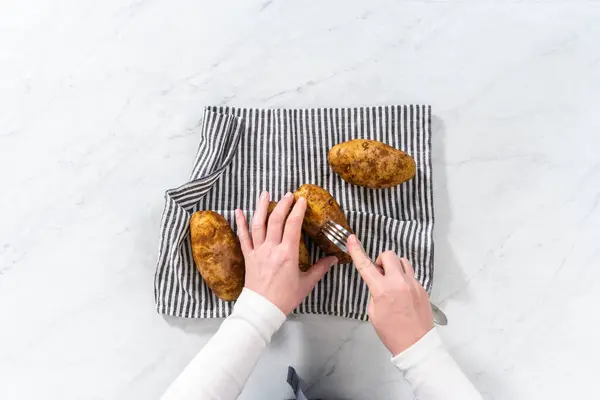 stock image Flat lay. Pressure Cooker Baked Potatoes. Poking raw potatoes with a fork to prepare baked potatoes.