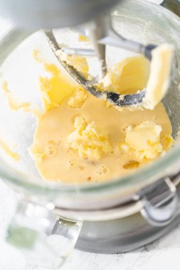Mixing ingredients in kitchen electric mixer to bake American flag mini cupcakes.
