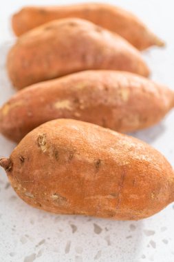 Fırında kızartılmış tatlı patates yapmak için cam karıştırma kabında ölçülmüş malzemeler.