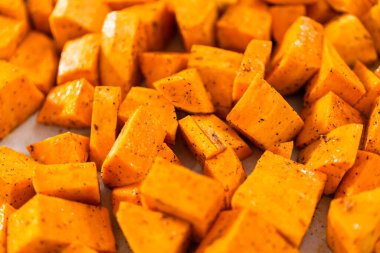 Fırında kızartılmış tatlı patates yapmak için parşömen kağıdıyla kaplı fırında tatlı patatesler..