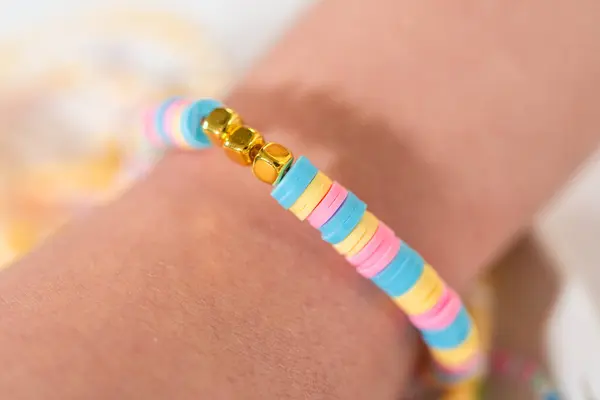 Little girls charming bracelets adorned with clay and sea beads.