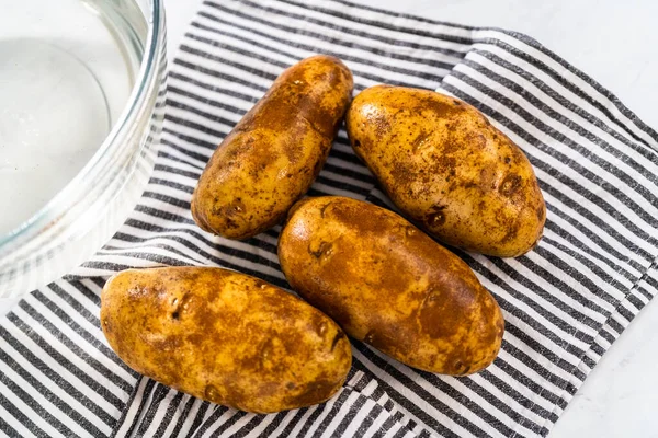 Pressure Cooker Baked Potatoes. Drying washed raw potatoes with a kitchen towel.