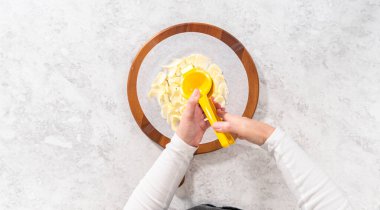 Flat lay. Assembling butter board with vegetables and bread on a round wood cutting board.