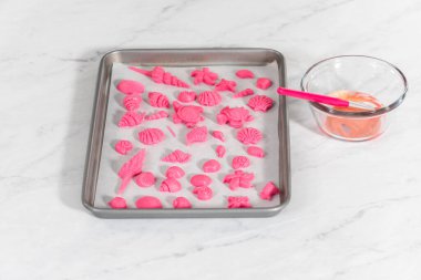 Çikolata soslu krakerleri süslemek için parıltılı çikolatalar boyuyorlar..