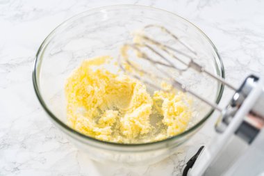 Mini vanilyalı kekler ve ombre pembe kremalı krema pişirmek için büyük bir karıştırma kabında malzemeler karıştırılıyor..