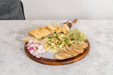 Tahtaya sebze ve ekmek koyarak tereyağı monte etmek..