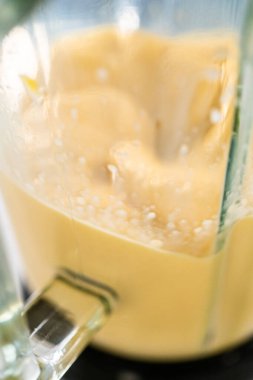 Mutfak blendırında mango boba smoothie hazırlamak için malzemeler karıştırılıyor.