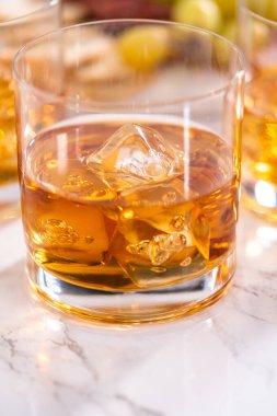 Buzlu viski, viski bardağında, beyaz mermer yüzeyde..