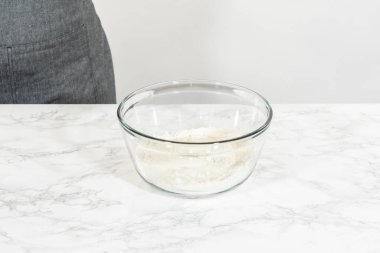 Büyük bir bardakta mayasız tarçınlı kek pişirmek için karışımı karıştırıyorum..