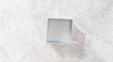 Flat lay. Lining square cheesecake pan with parchment paper sheet to prepare eggnog fudge.