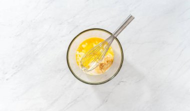 Düz yatıyordu. Limonlu yaban mersinli kek pişirmek için büyük bir bardakta ıslak malzemeler karıştırıyorum..