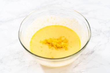 Küçük Paskalya ekmeği pişirmek için ıslak malzemeleri büyük bir bardakta karıştırıyorum..