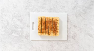 Flat lay. Homemade eggnog fudge pieces on a white cutting board.