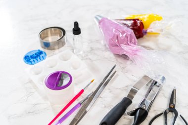 Vanilyalı ve çikolatalı kekleri incelikle süsleyip onları doğum günü kutlaması için uygun ziyafetlere dönüştürüyor..