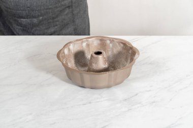 Limonlu kek pişirmek için sebze boyası ve un ile yağlı metal kek tepsisi..